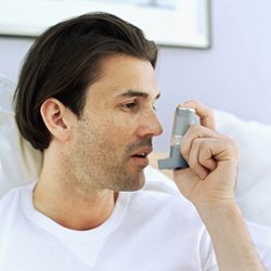 Close-up of a young man using an inhaler